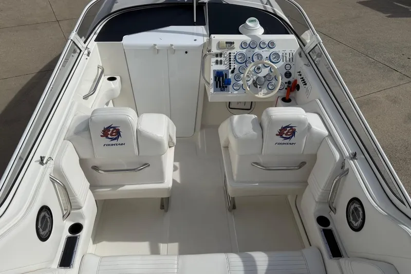 Slide: The Image of 2000 Fountain 38 Lightning boat interior with white seating and detailed dashboard controls. - 7
