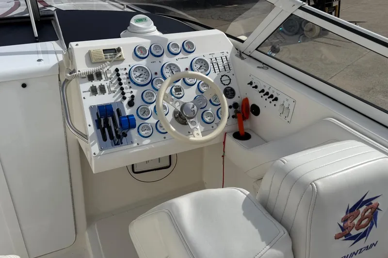 Slide: The Image of Control panel of a 2000 Fountain 38 Lightning boat with gauges and steering wheel. - 8