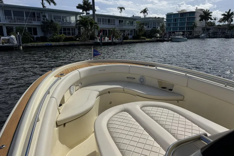 Slide: The Image of 2023 Chris-Craft Catalina 30 boat with luxurious seating, docked near waterfront homes. - 4