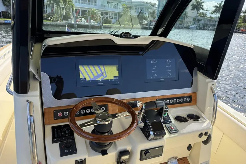 Slide: The Image of 2023 Chris-Craft Catalina 30 helm with navigation screens and wooden steering wheel. - 7