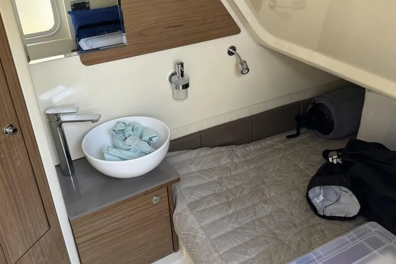 Slide: The Image of 2023 Chris-Craft Catalina 30 interior cabin with sink, mirror, and storage. - 9