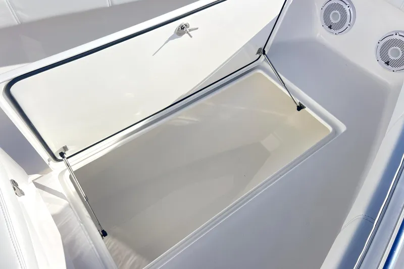 Slide: The Image of Open storage compartment on 2026 Contender 25 Tournament boat with speakers visible. - 16