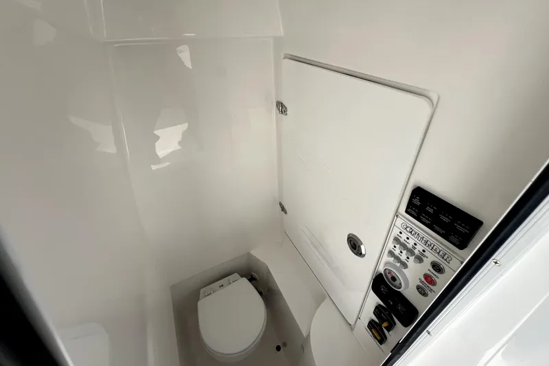 Slide: The Image of Interior of 2026 Contender 25 Tournament boat, featuring a compact marine toilet. - 32