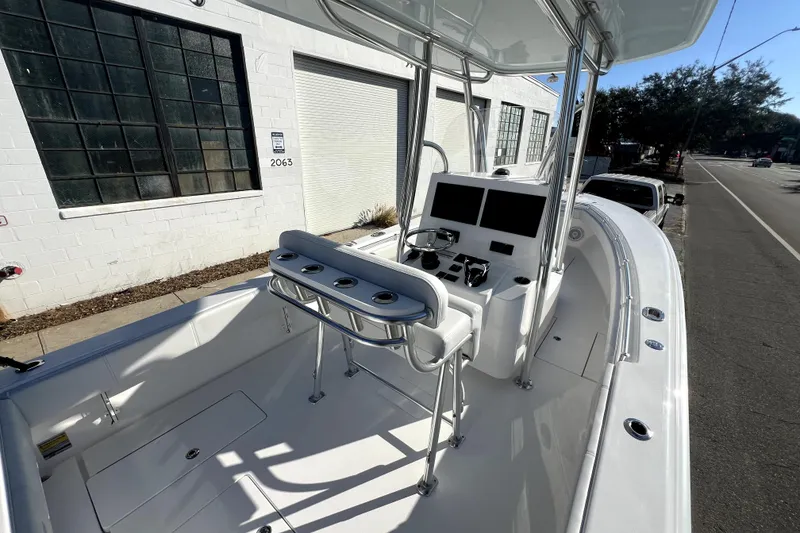 Slide: The Image of 2026 Contender 25 Tournament boat with sleek console and seating, parked near industrial building. - 7