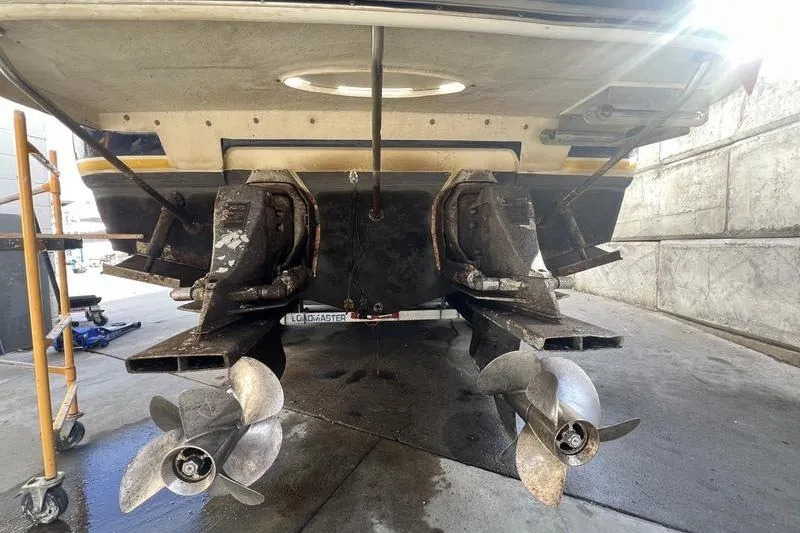 Slide: The Image of 2005 Larson Cabrio 290 boat with dual propellers in a maintenance area. - 12