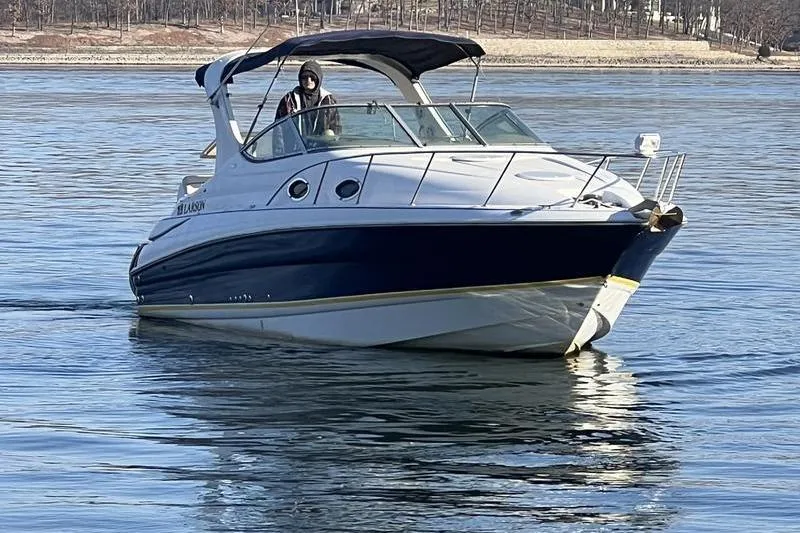 Slide: The Image of 2005 Larson Cabrio 290 boat cruising on calm water. - 9