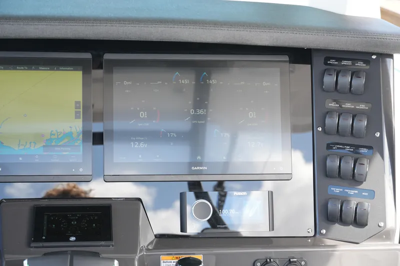 Slide: The Image of 2026 Blackfin 332 CC boat dashboard with Garmin navigation displays and control switches. - 41