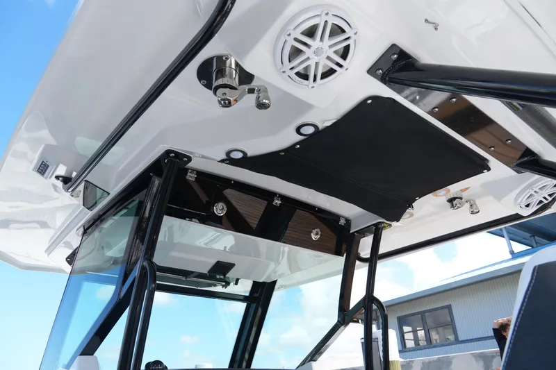 Slide: The Image of 2026 Blackfin 332 CC boat's overhead console with speakers and sturdy frame. - 44