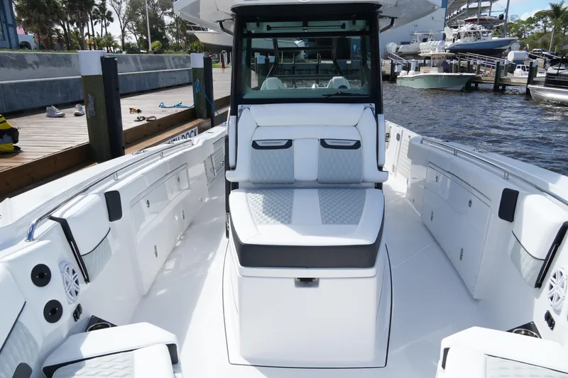 Slide: The Image of 2026 Blackfin 332 CC boat interior with sleek seating and modern design at a marina. - 48