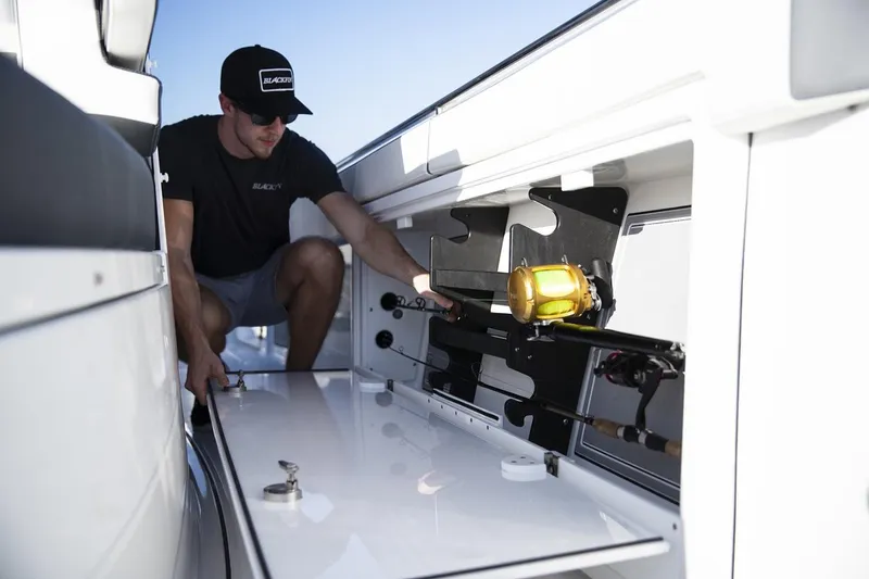 Slide: The Image of Manufacturer Provided Image: Man organizing fishing gear on 2026 Blackfin 332 CC boat. - 8