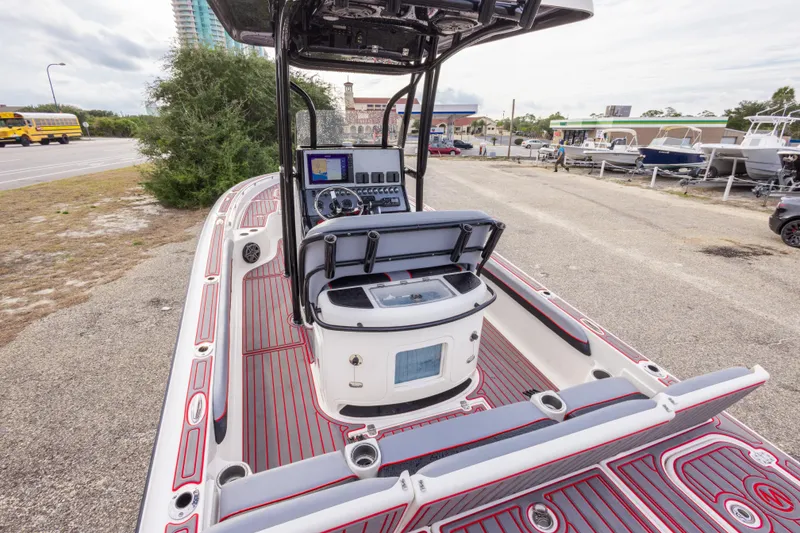 Slide: The Image of 2018 ShearWater 26 Carolina boat with modern dashboard and seating, parked near a road. - 10
