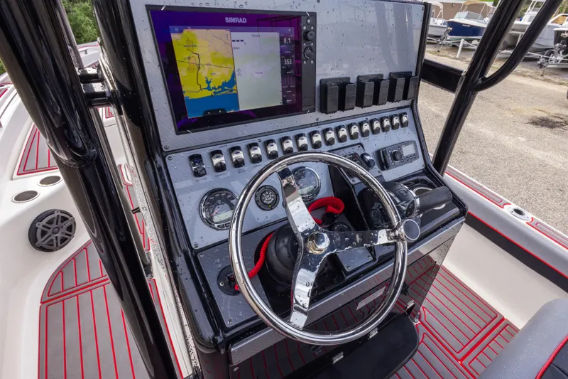 Slide: The Image of 2018 ShearWater 26 Carolina boat dashboard with steering wheel and navigation display. - 18