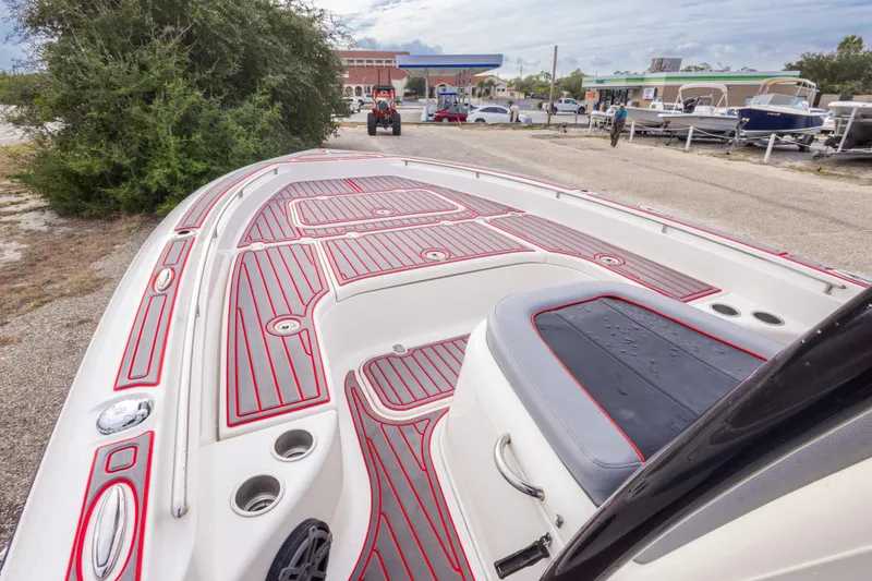 Slide: The Image of 2018 ShearWater 26 Carolina boat with red and gray deck, parked near marina. - 21