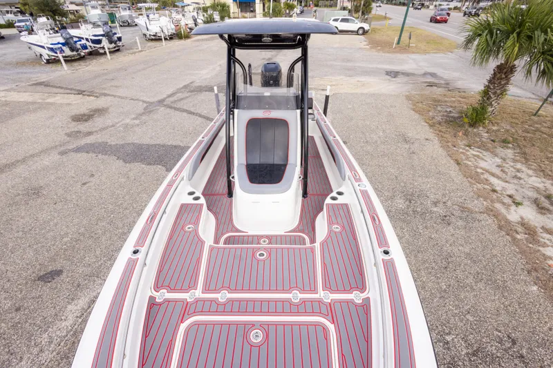 Slide: The Image of 2018 ShearWater 26 Carolina boat with sleek deck design, parked on a marina lot. - 24
