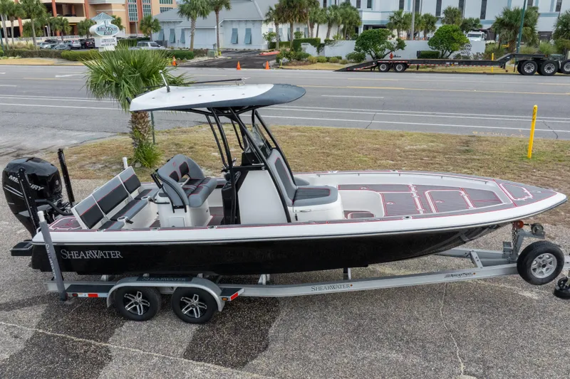 Slide: The Image of 2018 ShearWater 26 Carolina boat on trailer, parked near road with palm trees. - 32