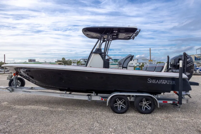 Slide: The Image of 2018 ShearWater 26 Carolina boat on trailer, side view, under cloudy sky. - 6