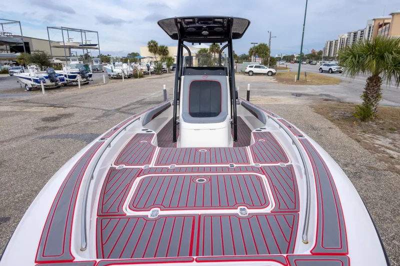 Slide: The Image of 2018 ShearWater 26 Carolina boat with red and gray deck, parked in a marina. - 8