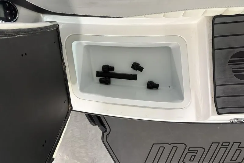 Slide: The Image of 2015 Malibu Wakesetter 247 LSV storage compartment with black fittings inside. - 30