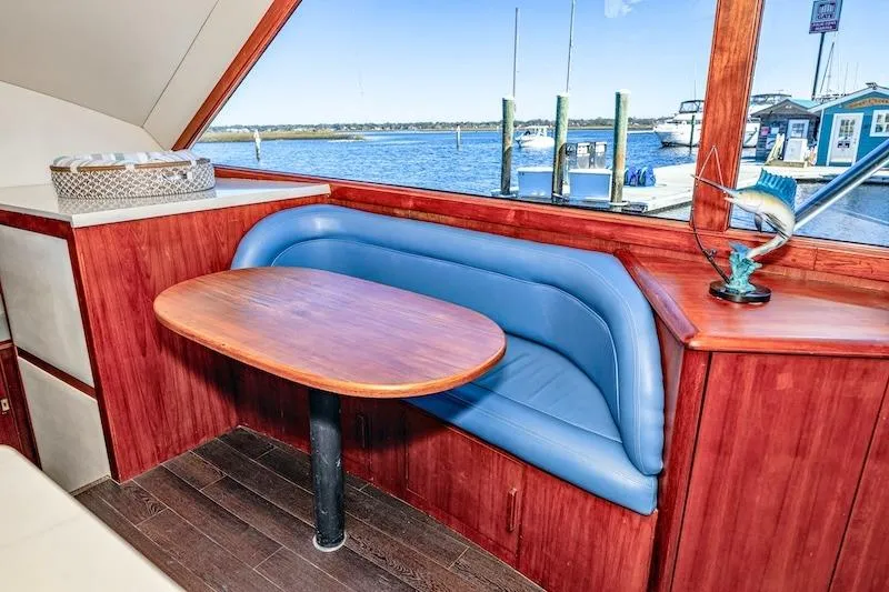 Slide: The Image of Interior of 1991 Ocean Yachts 53 Super Sport with blue seating and wooden table. - 37