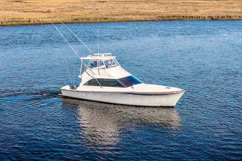 Slide: The Image of 1991 Ocean Yachts 53 Super Sport cruising on a calm blue waterway. - 5