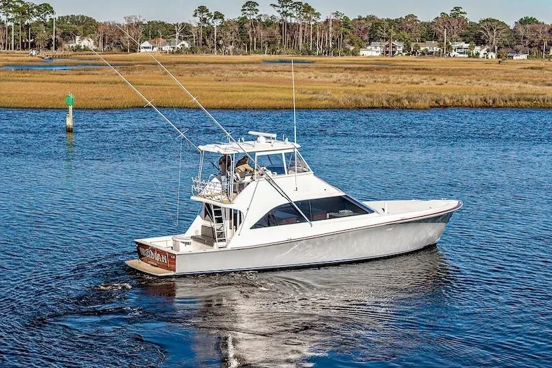 Slide: The Image of 1991 Ocean Yachts 53 Super Sport cruising on a serene waterway. - 6