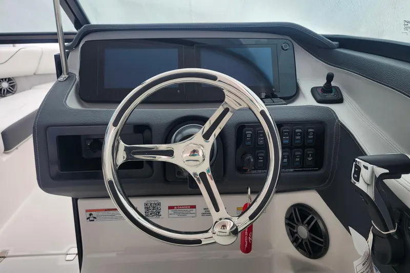 Slide: The Image of 2026 Regal LX6 boat dashboard with modern steering wheel and control panel. - 14