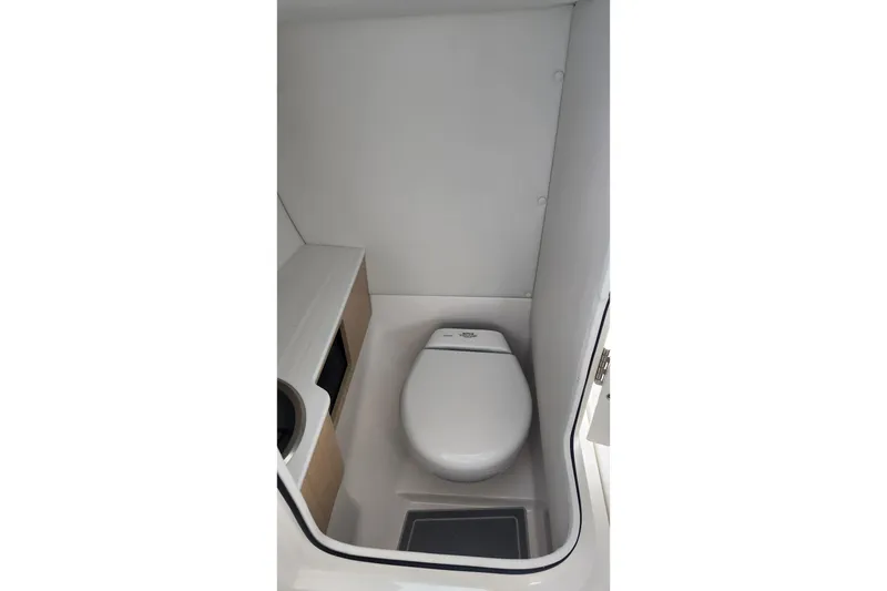 Slide: The Image of 2026 Regal LX6 boat interior with compact marine toilet and storage space. - 16