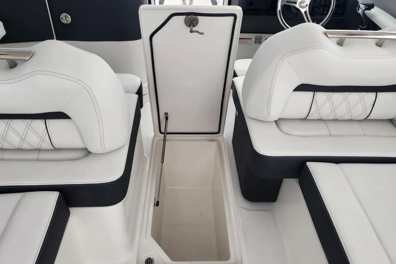 Slide: The Image of 2026 Regal LX6 boat interior with white seating and open storage compartment. - 19