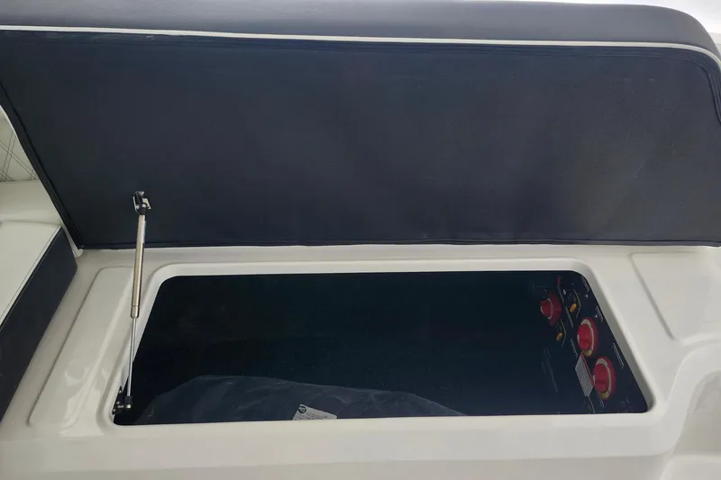 Slide: The Image of Open storage compartment in 2026 Regal LX6 boat, showcasing interior details and controls. - 21