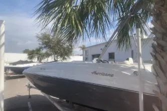 Slide: The Image of 2023 Hurricane SunDeck Sport 188 OB boat under palm trees in a sunny marina. - 8