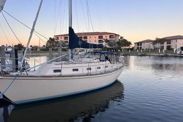 The Image of 1994 Island Packet 320 sailboat docked in a serene marina at sunset. - 0