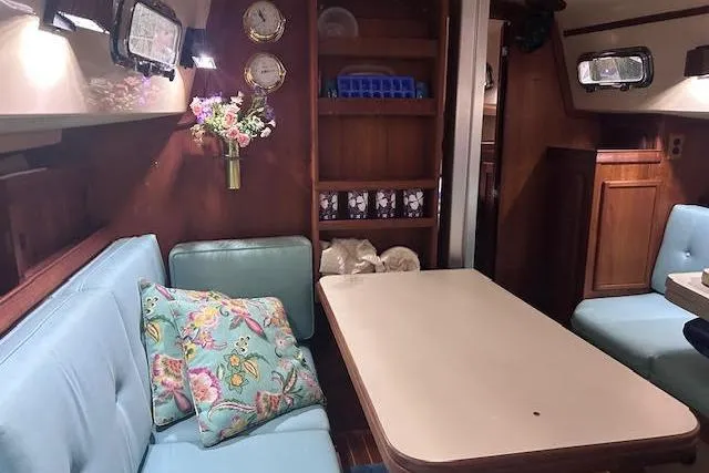 Slide: The Image of Cozy interior of 1994 Island Packet 320 sailboat with dining area and floral decor. - 12