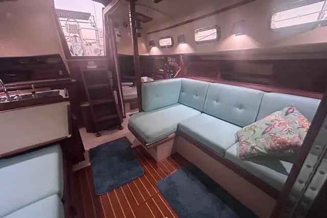 Slide: The Image of Interior of a 1994 Island Packet 320 sailboat with cozy seating and nautical decor. - 14