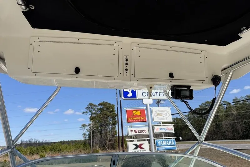 Slide: The Image of 2005 Triton 2486 CC boat console with overhead storage and electronic equipment. - 17