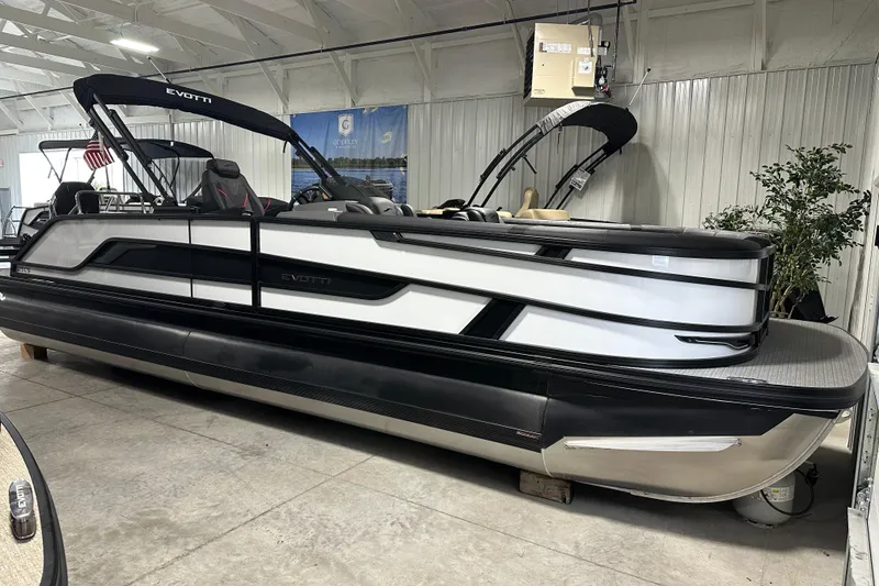 The Image of 2026 Evotti 725 QL pontoon boat in showroom, sleek design with black and white accents. - 0