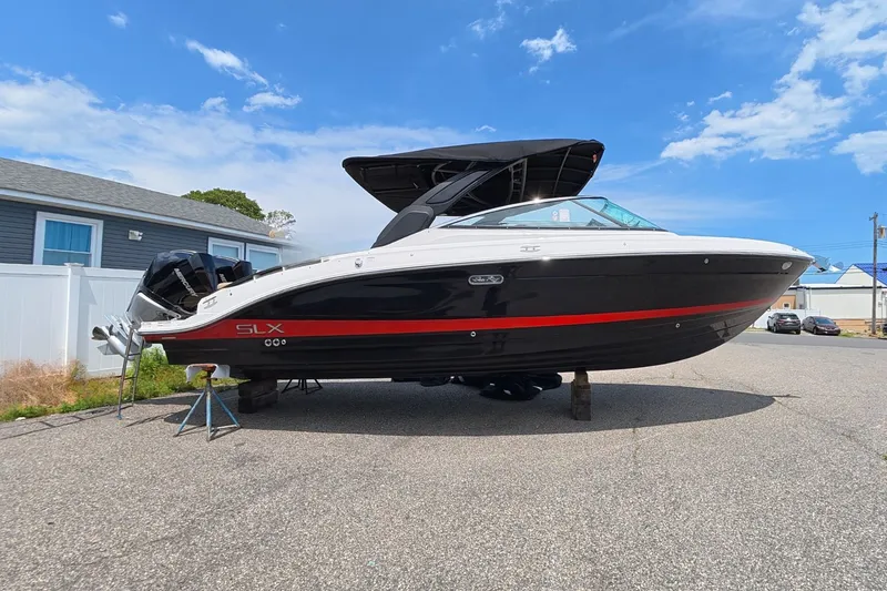 Slide: The Image of A Sea Ray SLX 280 Outboard boat is on a parking lot. - 0