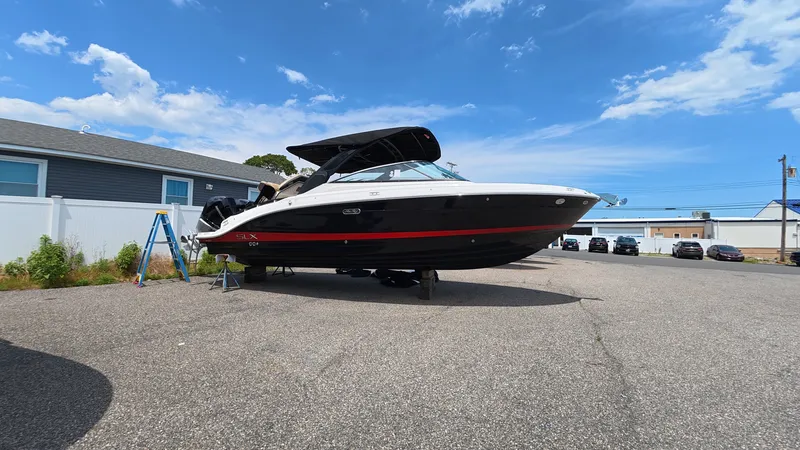 Slide: The Image of A 2026 Sea Ray SLX 280 Outboard is parked on a lot. The sky is clear and blue. - 35