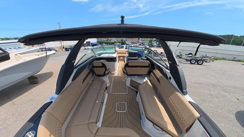 Slide: The Image of The Sea Ray SLX 280 Outboard boat features beige seating and a black canopy. - 7
