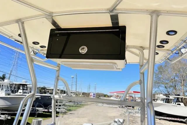 Slide: The Image of 2017 Skeeter SX240 boat with T-top and storage compartment, parked outdoors. - 8