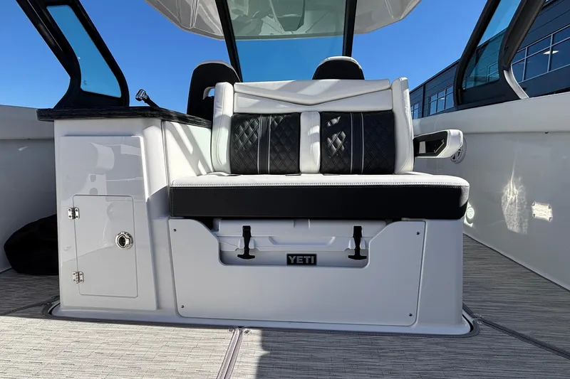 Slide: The Image of 2026 Monterey Elite 30 OB boat interior with cushioned seating and Yeti cooler storage. - 12