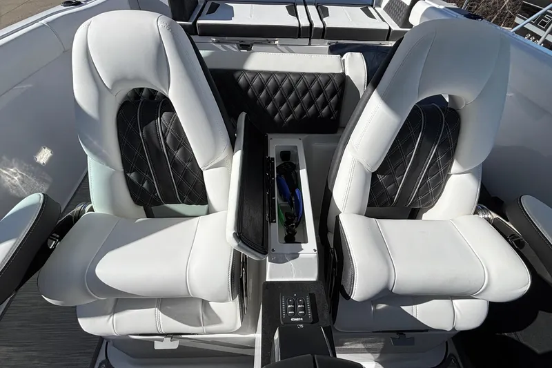 Slide: The Image of Luxurious seating in the 2026 Monterey Elite 30 OB boat, featuring sleek white and black upholstery. - 26