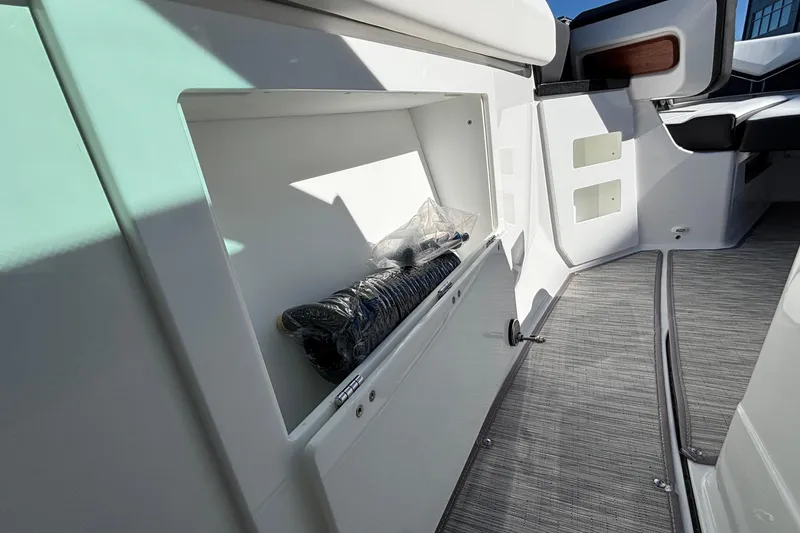 Slide: The Image of 2026 Monterey Elite 30 OB boat interior storage compartment with coiled rope. - 51