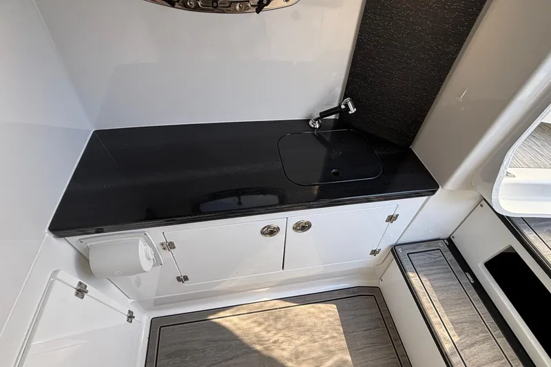 Slide: The Image of 2026 Monterey Elite 30 OB boat interior with sleek black countertop and modern sink. - 66