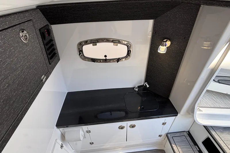 Slide: The Image of 2026 Monterey Elite 30 OB boat interior with sleek black countertop and modern fixtures. - 67
