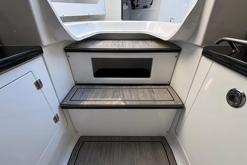 Slide: The Image of Interior steps of 2026 Monterey Elite 30 OB boat, featuring sleek wood finish. - 70