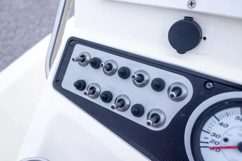 Slide: The Image of Control panel of a 2013 Skeeter SX210 boat with switches and gauge. - 25
