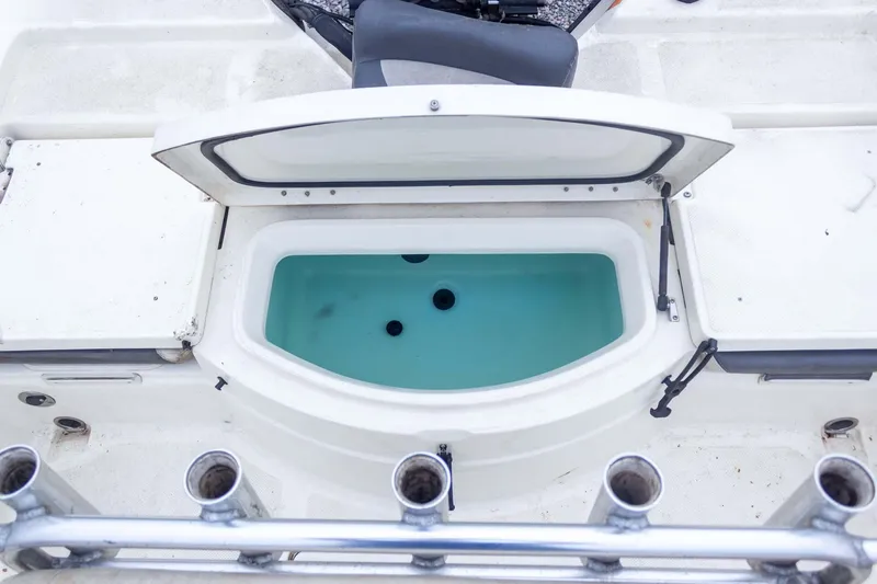 Slide: The Image of 2013 Skeeter SX210 boat livewell with open lid and rod holders. - 31