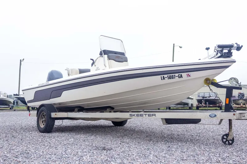 Slide: The Image of 2013 Skeeter SX210 boat on trailer, parked on gravel lot. - 6