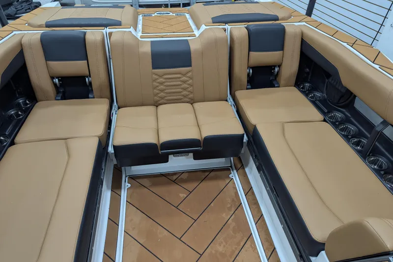 Slide: The Image of 2026 Malibu Wakesetter 26 LSV interior with tan and black seating, cup holders, and stylish design. - 13