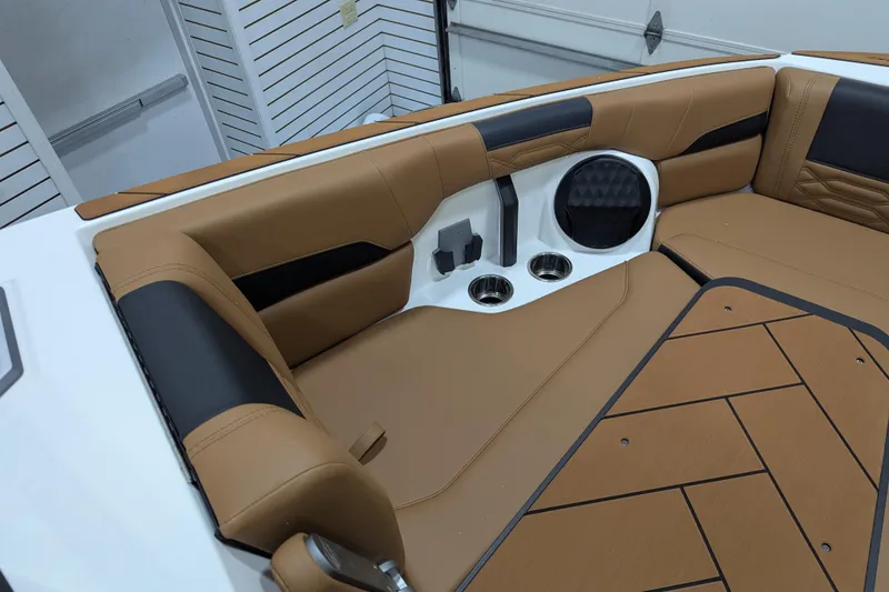 Slide: The Image of 2026 Malibu Wakesetter 26 LSV interior with tan upholstery and cup holders. - 7